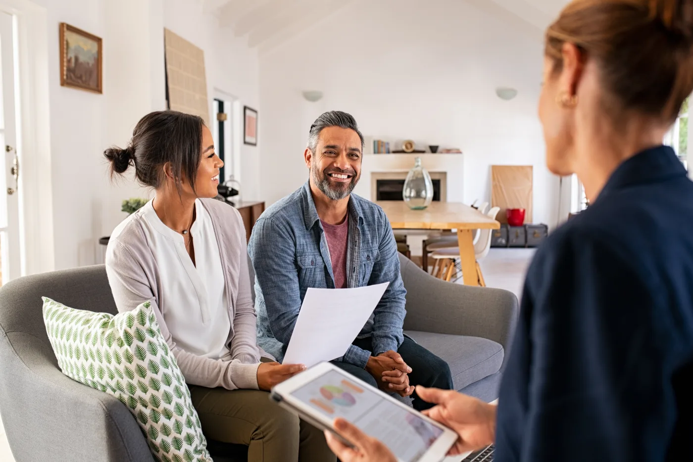 A couple talking with a financial advisor in their home